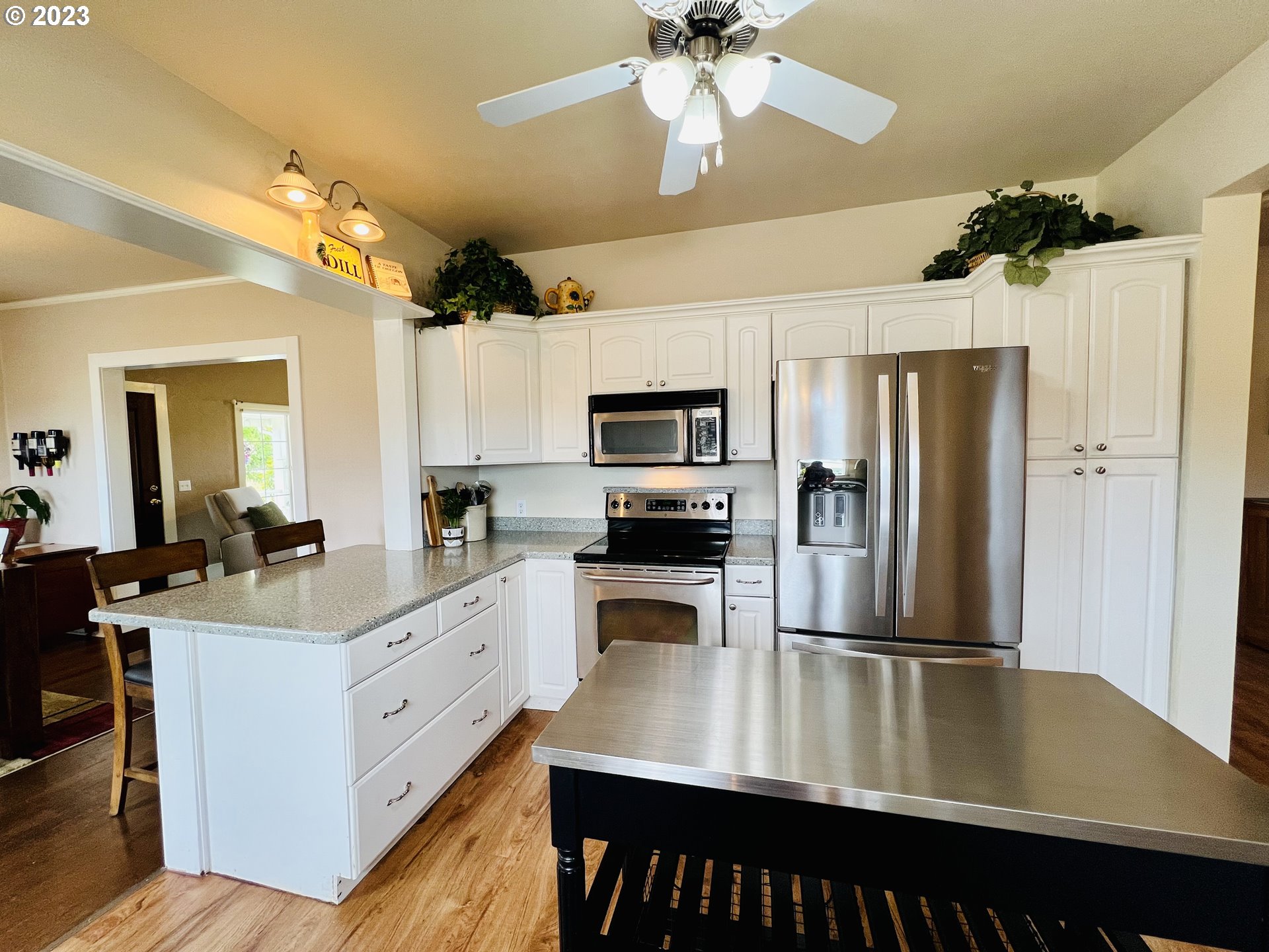 5393 Nonpareil Road Sutherlin, OR 97479 - Photo 13 of 42 a kitchen with a refrigerator a sink and a stove top oven with wooden floor