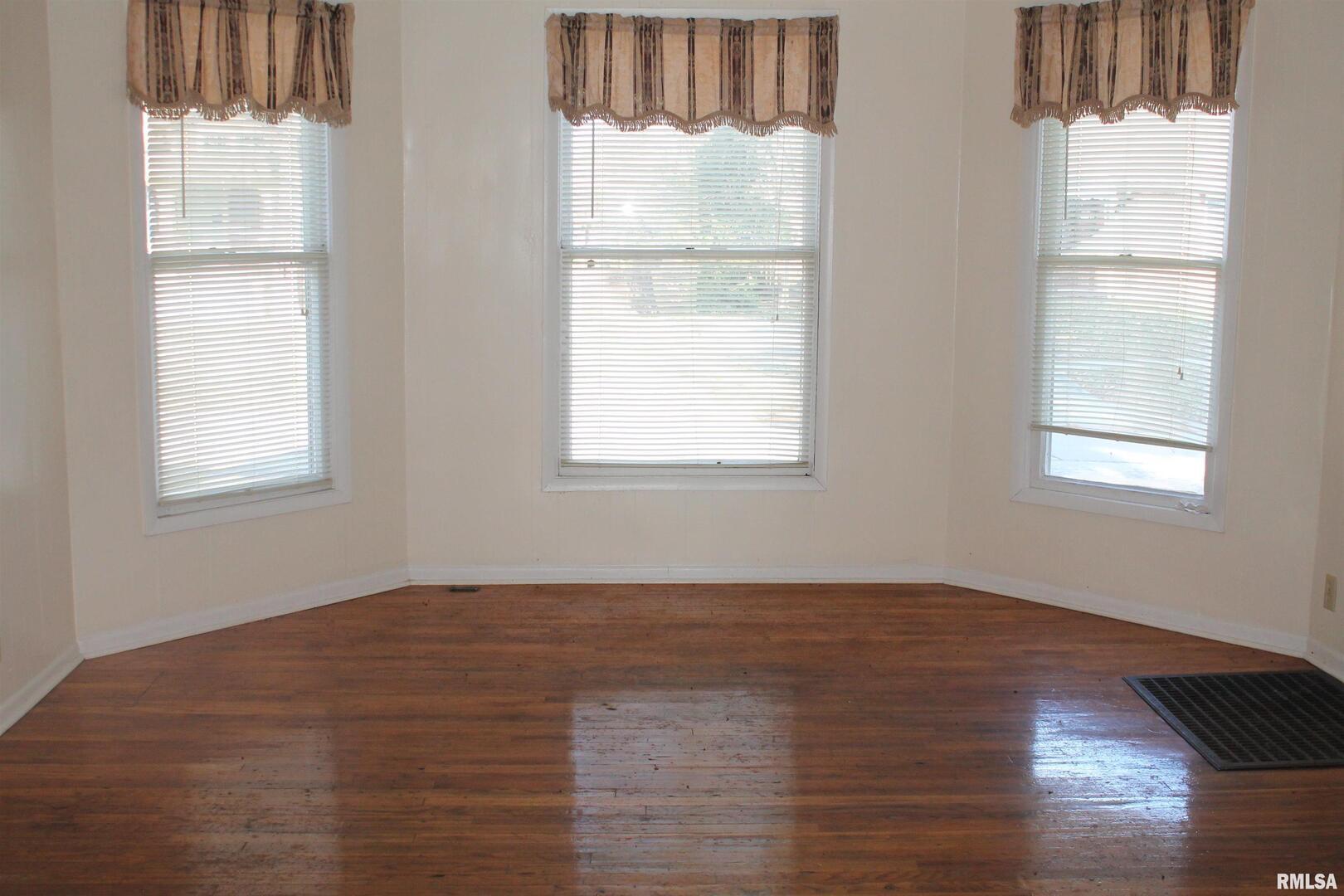 701 West Cherry Street, Unit 1 Carbondale, IL 62901 - Photo 3 of 9 an empty room with wooden floor and windows