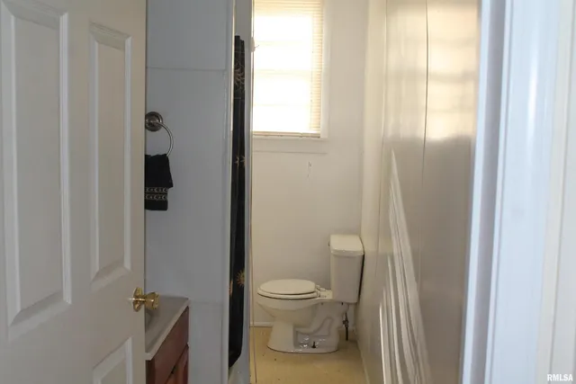 a bathroom with a granite countertop shower a toilet and a sink