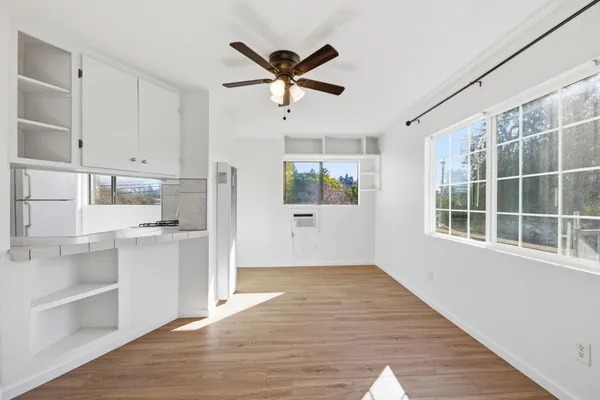 a view of a kitchen with wooden floor and a ceiling fan