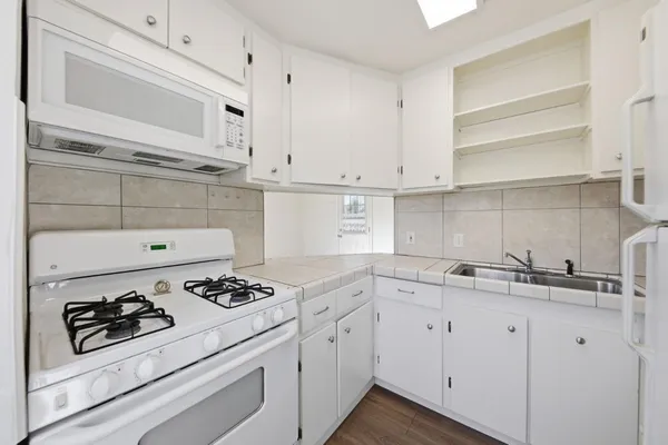 a kitchen with cabinets and white appliances