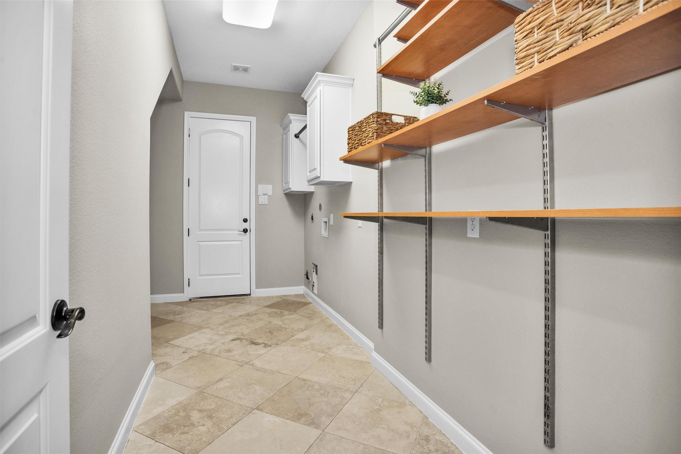 27910 Hansons Court Spring, TX 77386 - Photo 27 of 50 The spacious laundry and mudroom is equipped with Elfa adjustable shelving, easily accessible under the stair storage, upper storage cabinets above W/D area