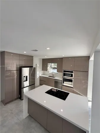 a kitchen with stainless steel appliances wooden cabinets and refrigerator