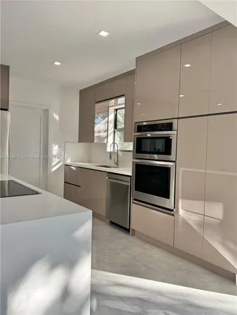 a kitchen with stainless steel appliances kitchen island granite countertop a sink and a stove
