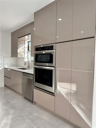 a kitchen with a refrigerator and white cabinets