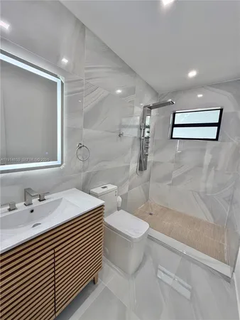 an empty room with windows and ceiling fan