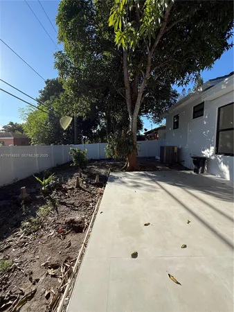 a view of backyard with large trees and plants