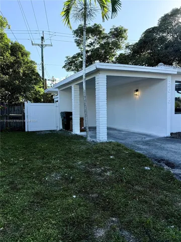 a view of empty room with kitchen and window