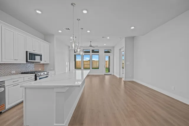 a view of a kitchen with center island and stainless steel appliances