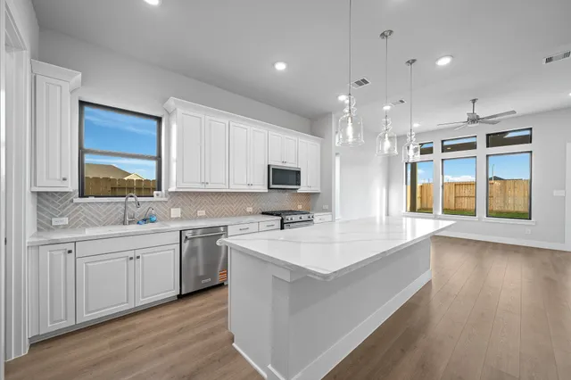 a large white kitchen with a large window