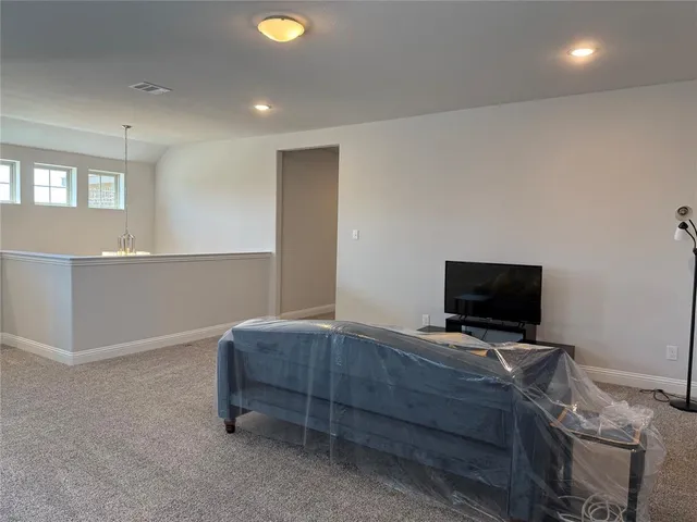 a living room with a bed furniture and a flat screen tv