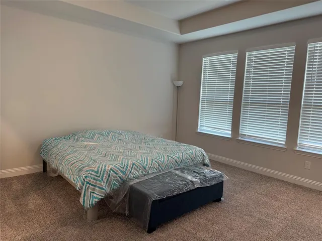 a spacious bedroom with a bed and a window