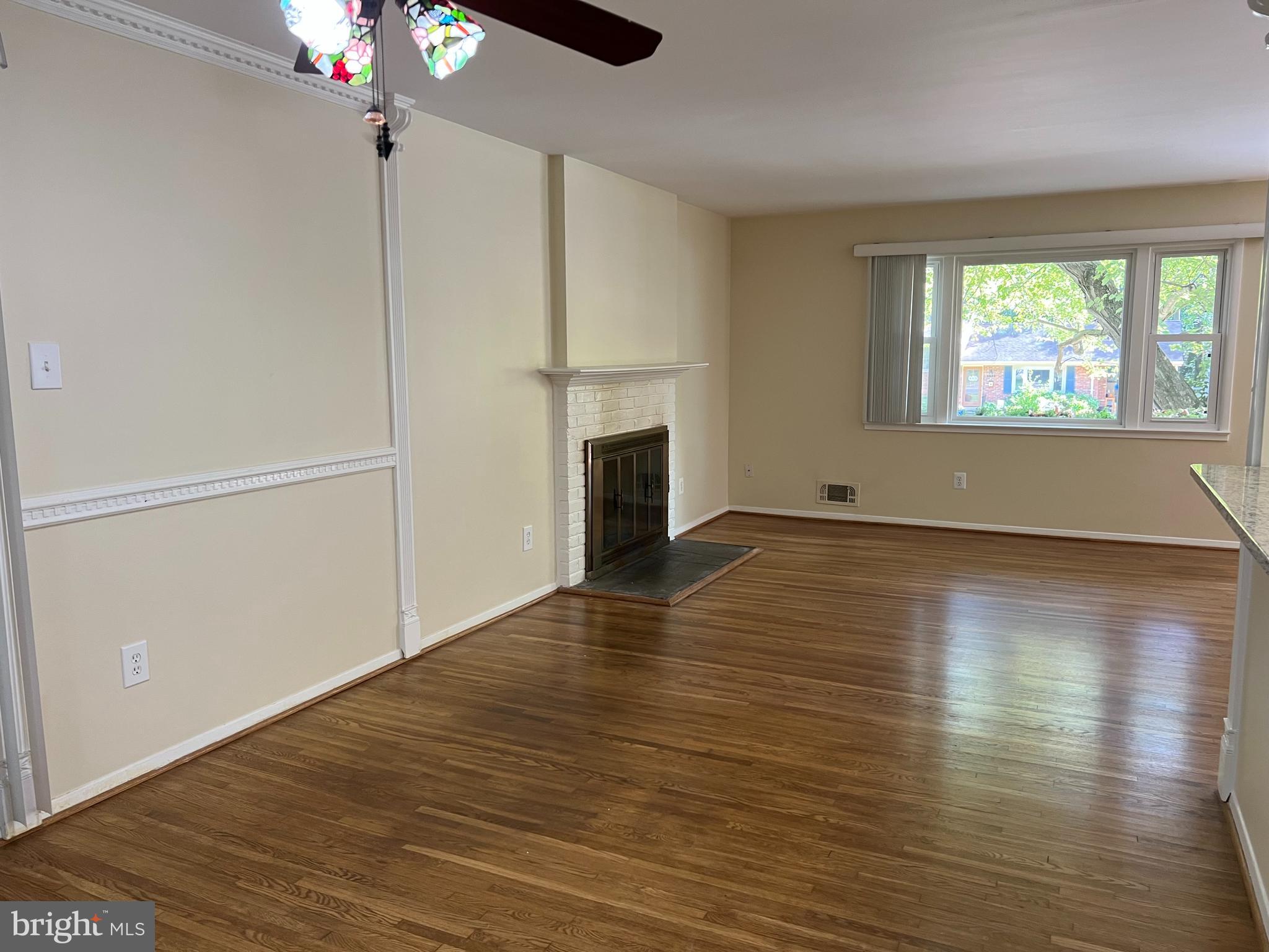 5626 Heming Avenue Springfield, VA 22151 - Photo 10 of 53 an empty room with wooden floor fireplace and windows