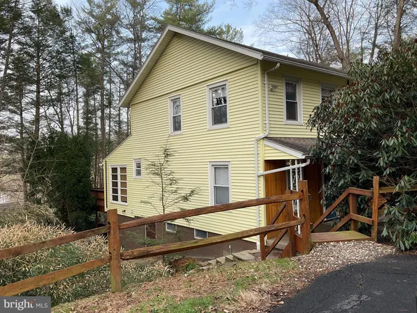 a view of a house with a yard and wooden fence