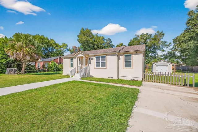 a view of a house with backyard and a tree