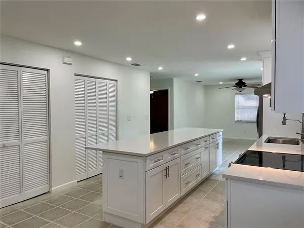 a kitchen with white cabinets and sink