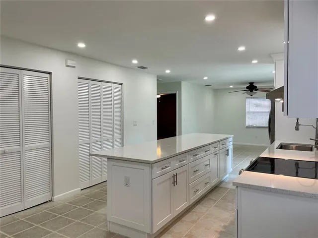 a kitchen with white cabinets and sink