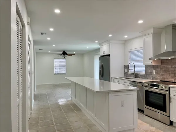 a kitchen with kitchen island granite countertop a stove and a sink