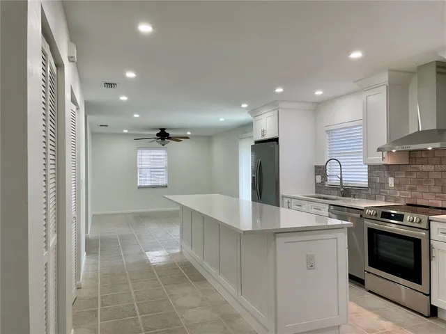 a kitchen with kitchen island granite countertop a stove and a sink