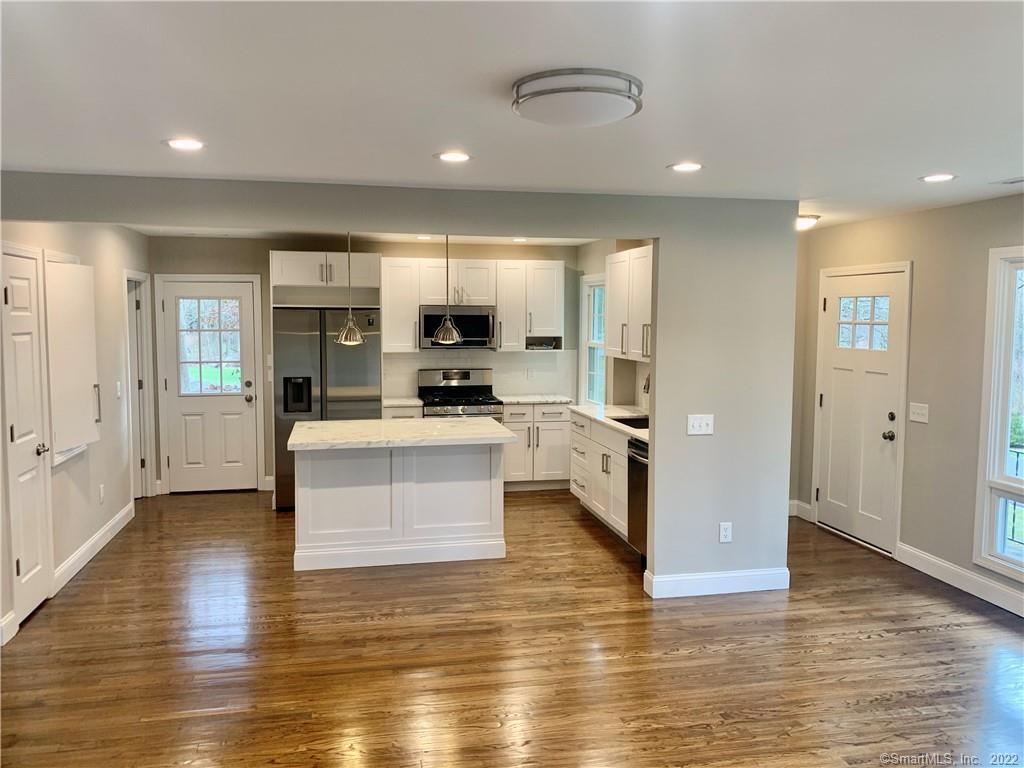 a view of kitchen with microwave a refrigerator and cabinets