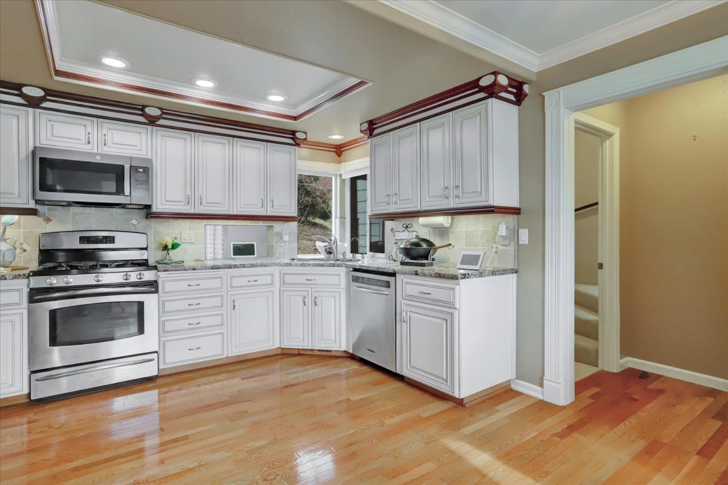 124 Ruby Ledge Court Grass Valley, CA 95945 - Photo 23 of 87 a kitchen with granite countertop a stove a sink and a microwave