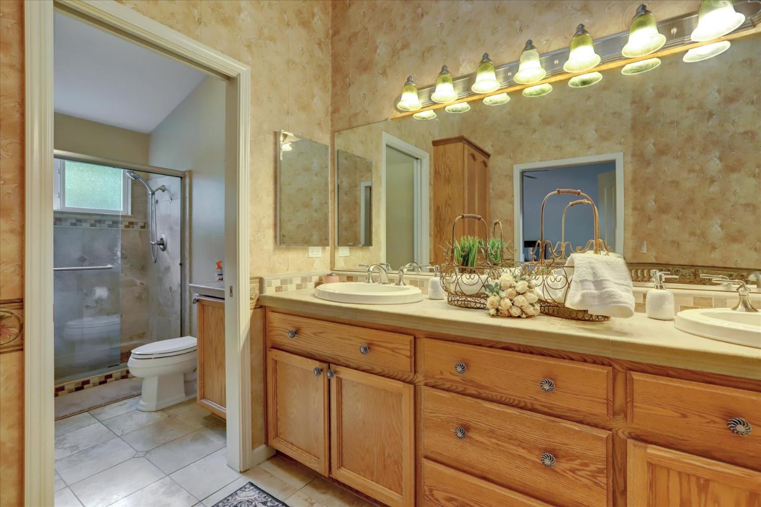 124 Ruby Ledge Court Grass Valley, CA 95945 - Photo 27 of 87 a bathroom with a double vanity sink mirror and toilet
