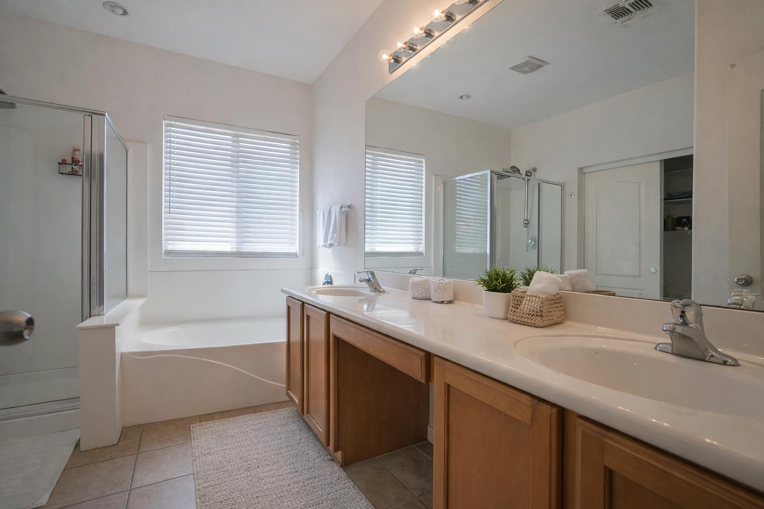 9377 West Milkweed Loop Phoenix, AZ 85037 - Photo 13 of 28 a bathroom with a sink double vanity granite tub shower and a mirror