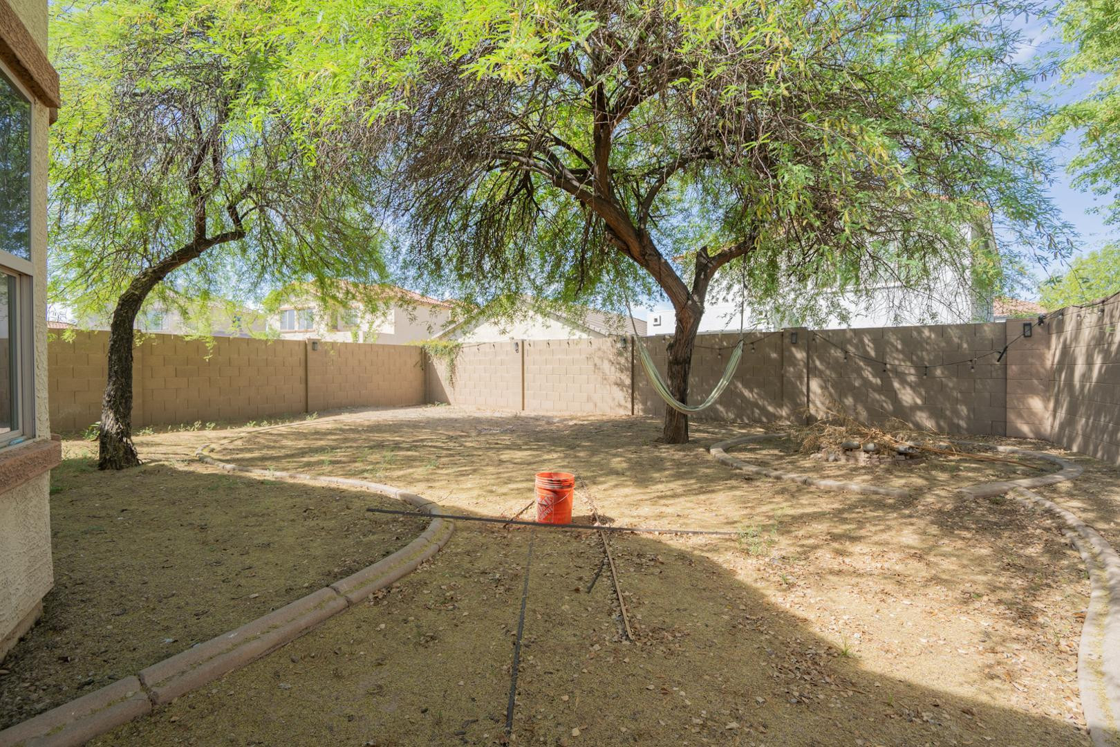 9377 West Milkweed Loop Phoenix, AZ 85037 - Photo 17 of 28 a backyard of a house with barbeque oven and trees