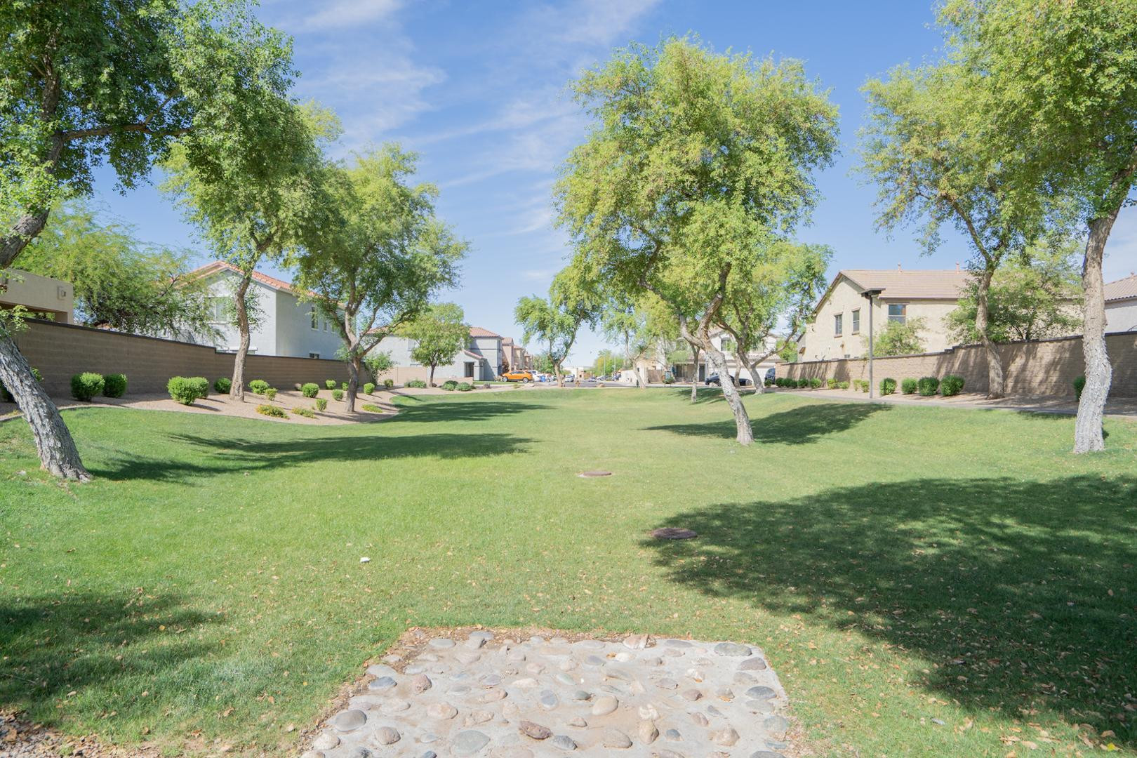 9377 West Milkweed Loop Phoenix, AZ 85037 - Photo 25 of 28 a view of a white house with a yard and sitting area
