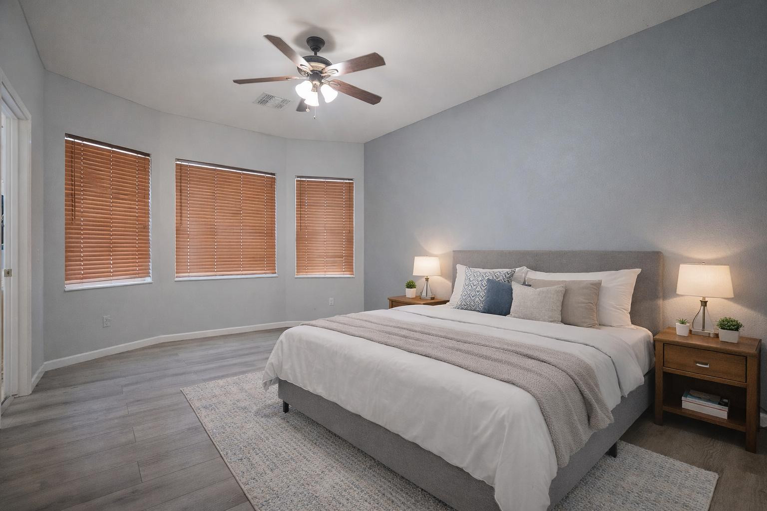 9377 West Milkweed Loop Phoenix, AZ 85037 - Photo 10 of 28 a bedroom with a large bed and a chandelier