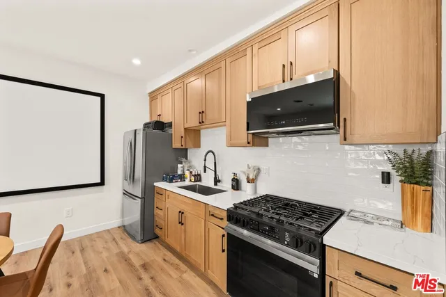 a kitchen with stainless steel appliances a stove microwave and sink