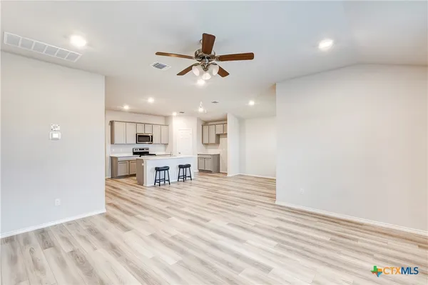 a living room with kitchen island furniture and a ceiling fan