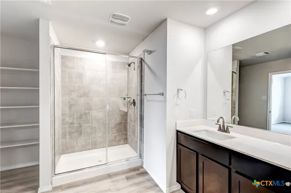 a bathroom with a shower sink and mirror