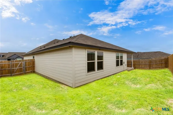 a backyard of a house with table and chairs