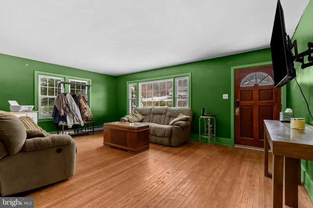 a living room with furniture a large window and a flat screen tv