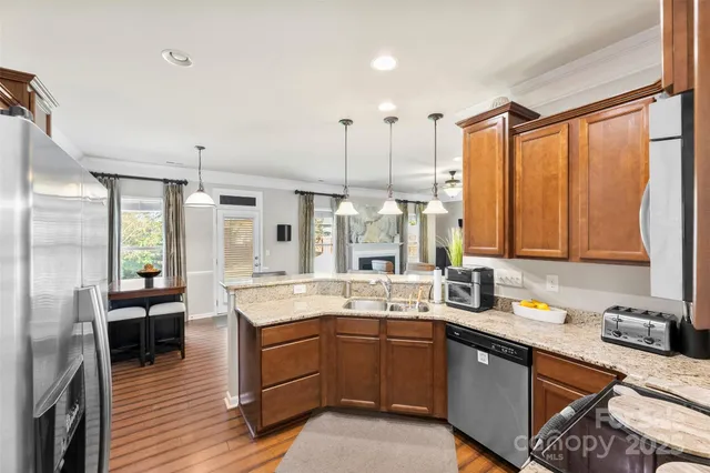 a large kitchen with kitchen island granite countertop a large window and stainless steel appliances