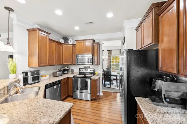 a kitchen with stainless steel appliances granite countertop sink stove top oven and cabinets