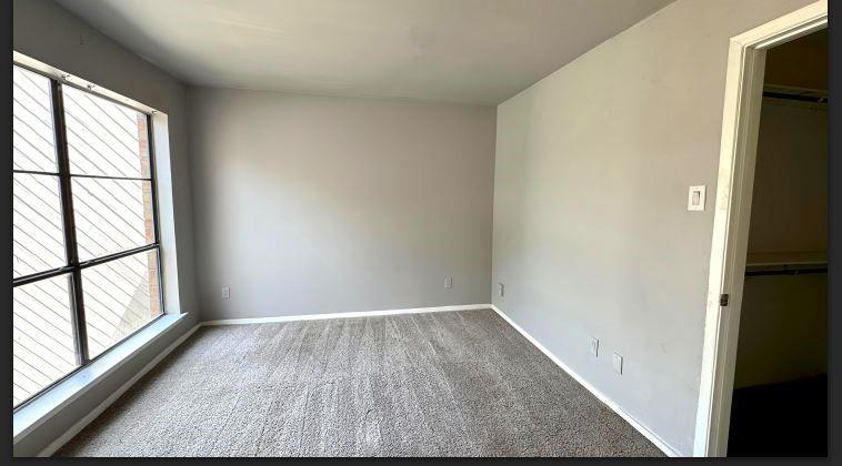 8110 Skillman Street, Unit 2057 Dallas, TX 75231 - Photo 8 of 16 Unfurnished bedroom with a walk in closet and carpet floors