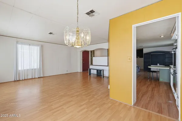 a view of a hallway with windows and chandelier