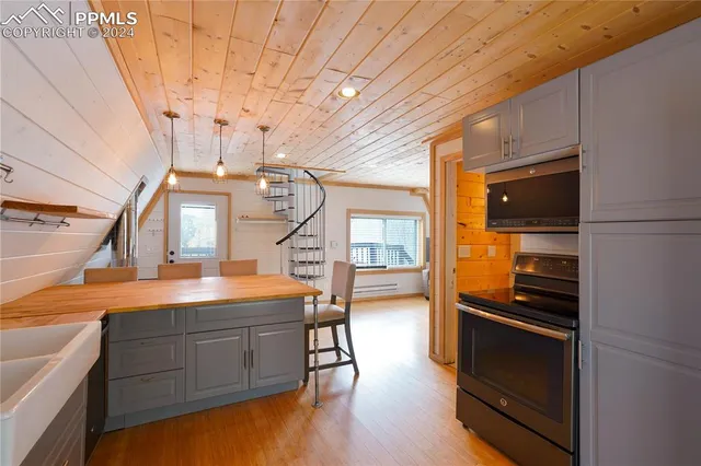 a kitchen with a refrigerator stainless steel appliances wooden floor and cabinets