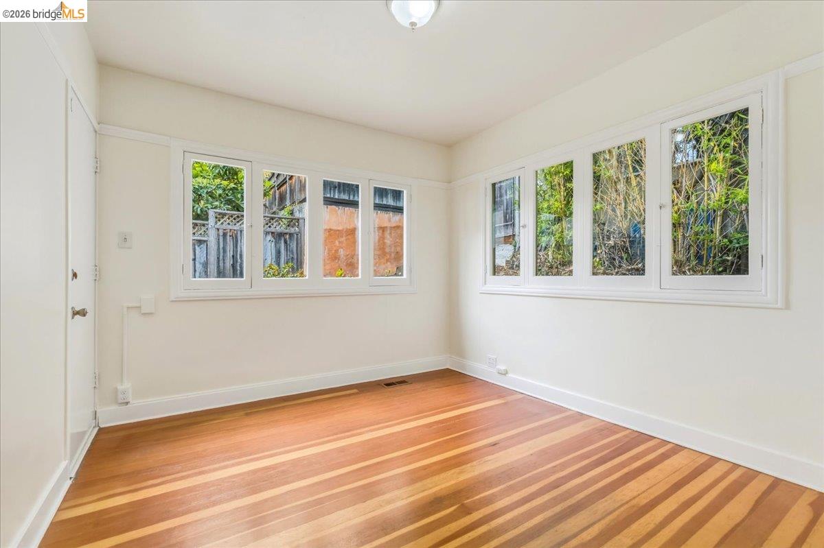 2403 Cedar Street Berkeley, CA 94708 - Photo 31 of 33 Hardwood flooring throughout, white baseboards, and multiple windows with white trim