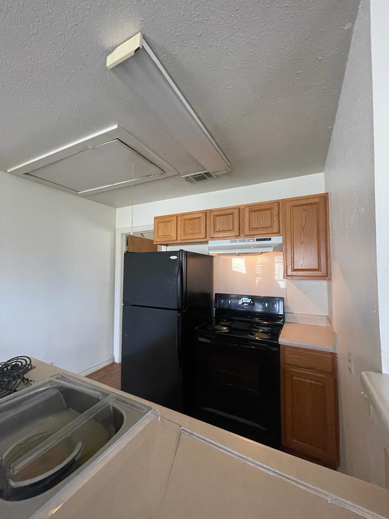 108 Austin Street, Unit B Kyle, TX 78640 - Photo 9 of 14 A compact kitchen with functional appliances and classic cabinetry.