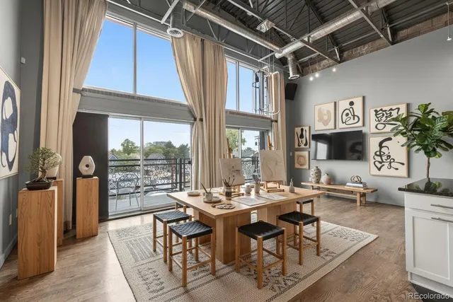 a room with lots of tables a large window and chairs