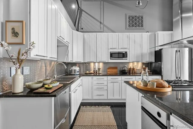 a kitchen with stainless steel appliances granite countertop a sink stove and refrigerator