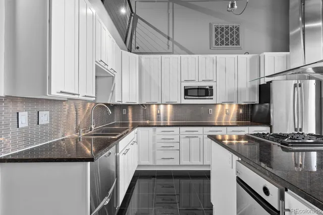 a kitchen with stainless steel appliances granite countertop a table chairs stove and white cabinets