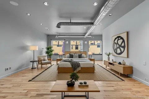 a living room with furniture potted plant and a large window
