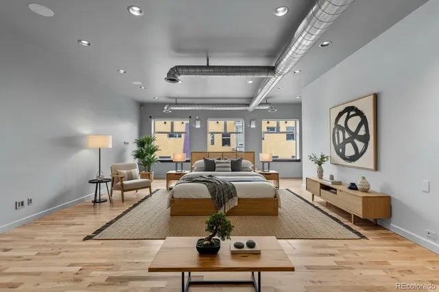 a living room with furniture potted plant and a large window