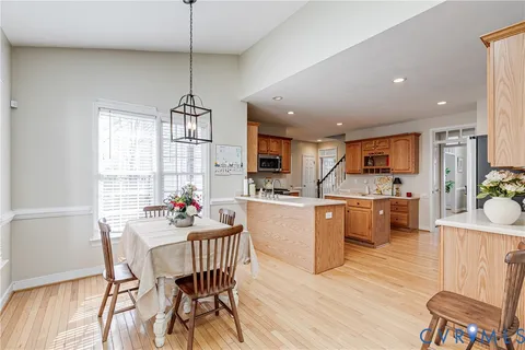 a dining room filled chandelier and wooden floor