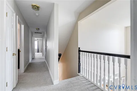 a view of a hallway with wooden floor and stairs