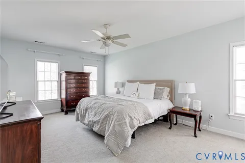 a spacious bedroom with a bed a dresser and a window